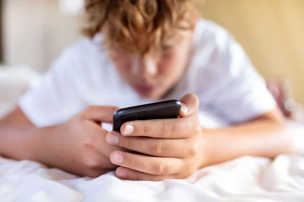 Imagem colorida de menino segurando celular pnad - Metrópoles