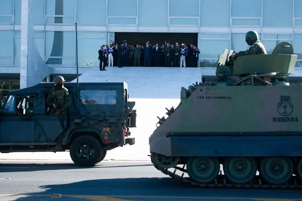 Bolsonaro e ministros assistem desfile de blindados em frente ao Planalto, Brasília. Na parte da frente passam veículos militares, enquanto ao fundo o presidente e demais espectadores assistem da rampa do palácio - Metrópoles