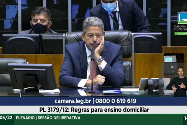 Deputado Arthur Lira, presidente da Câmara dos Deputados, assiste com semblante entediado e mão no queixo deputados do Novo e PSol brigarem no plenário da casa. Ele está sentado na mesa da presidência - Metrópoles