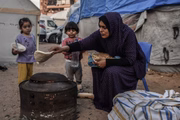 Mulher pega comida em Gaza