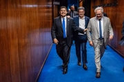 O presidente do Senado, Davi Alcolumbre (União-AP), ladeado pelo líder do governo no Congresso, Randolfe Rodrigues (PT-AP), e do ex-presidente da Casa Renan Calheiros (MDB-AL). Eles saíram abraçados após votação realizada com o fim do motim bolsonaristas.