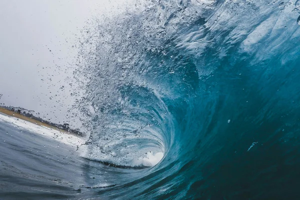Imagem colorida mostra uma onda no mar - Metrópoles
