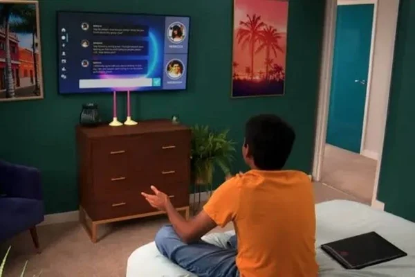 Rapaz sentando na cama de frente para a televisão é cena de The Circle