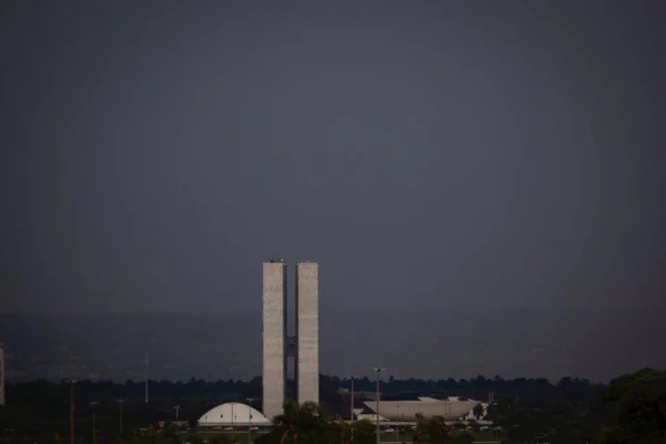 Congresso Nacional e céu escuro de chuva