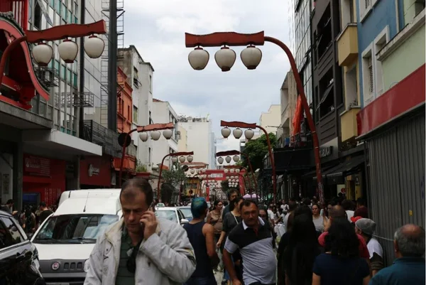 Imagem colorida mostra rua no bairro da Liberdade, no centro de São Paulo. a Via está dividida entre pedestres e carros - Metrópoles