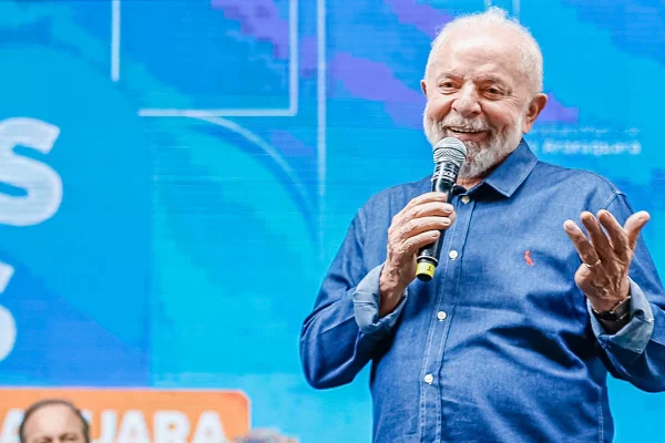 Imagem colorida mostra Lula falando ao microfone - Metrópoles