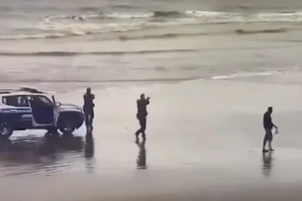 Imagem colorida de GCMs apontando a arma para um homem suspeito - Metrópoles