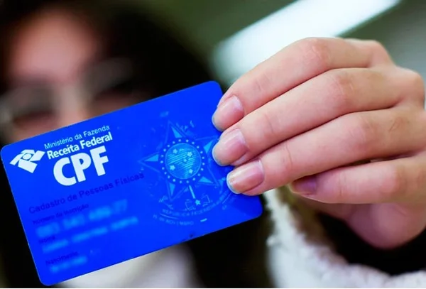Pessoa segurando CPF - Metrópoles
