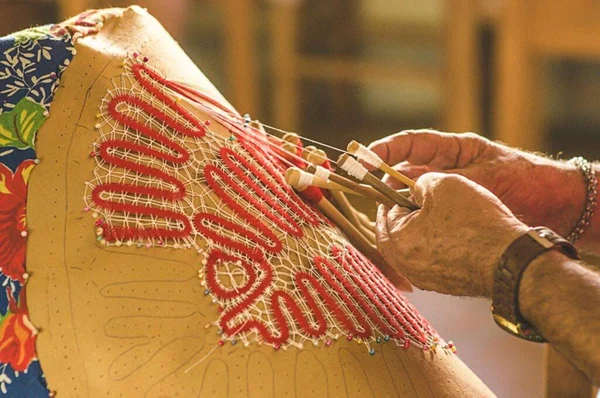 foto de uma mão produzindo peças artesanais de renda
