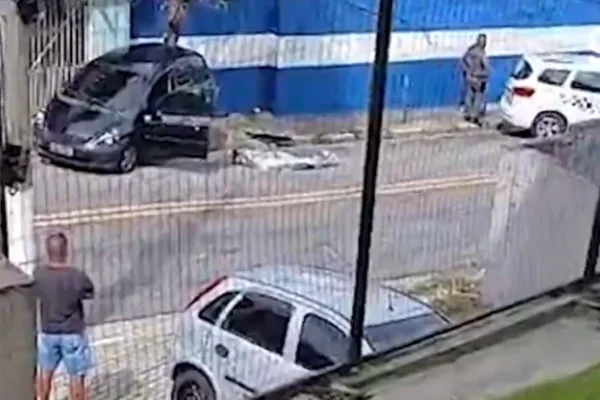 Viatura da PM está ao lado de corpo deitado na rua, envolto em papel laminado - Metrópoles