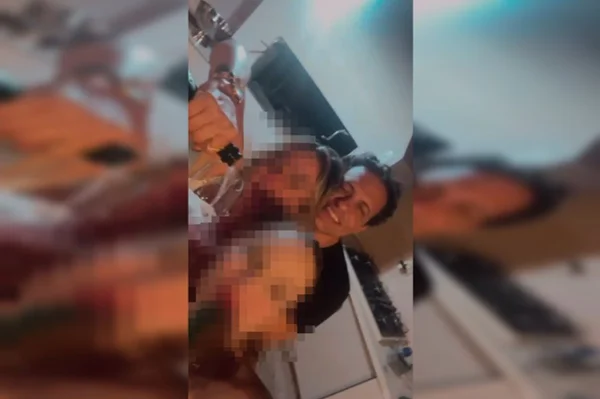 Duas mulheres dançando e bebendo com homem
