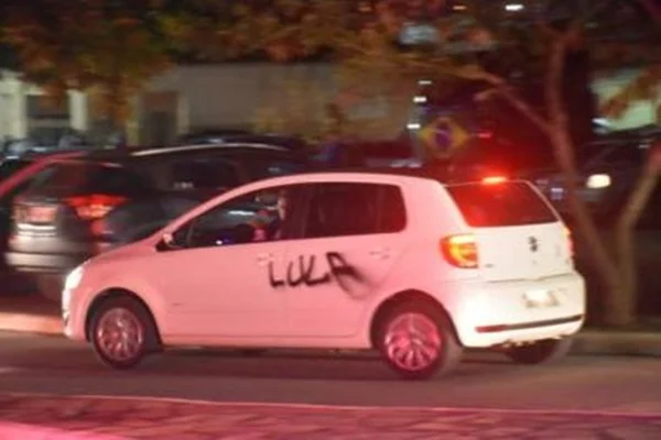 Carro branco pichado com o nome "Lula"