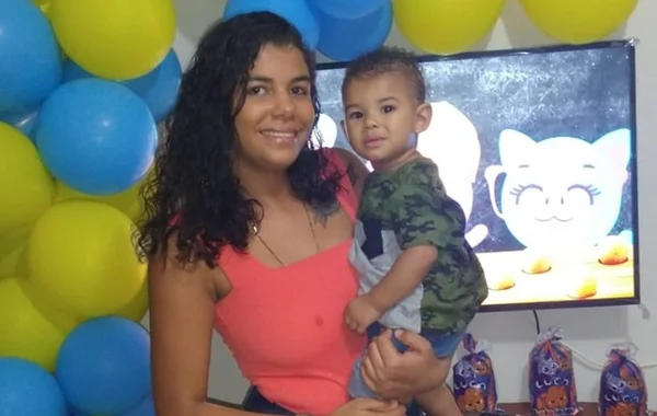 Mãe segura bebê André Benício no colo em festa de aniversário