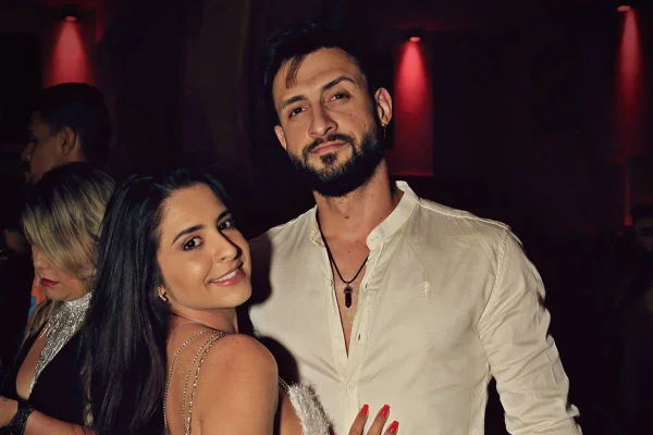 Havena Cep e o marido em foto colorida. Uma mulher branca, ao lado de um homem branco com blusa de botão branca - Metrópoles