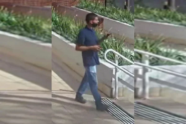 Homem caminhando com celular na mão