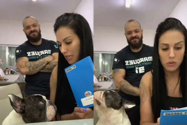 Foto colorida de duas pessoas com um cachorro sentado - Metrópoles