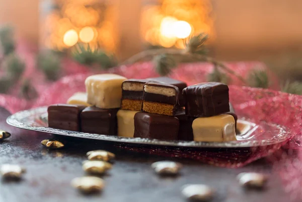 Imagem ilustrativa de chocolates em bandeja de prata sob enfeites natalinos - Metrópoles