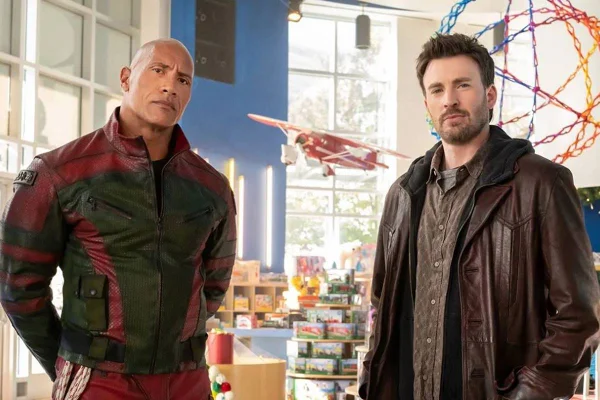 foto colorida de Dwayne Johnson e Chris Evans posando sérios - metrópoles