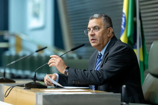 imagem colorida mostra deputado Gilmaci Santos. Ele está sentado, falando um microfone de uma mesa. é um homem grisalho, que usa óculos e veste terno preto com gravata azul - metrópoles