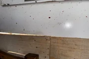 Possíveis respingos de sangue em uma madeira usada como parede de uma casa