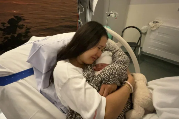 foto colorida mãe abraçando filha recém-nascida