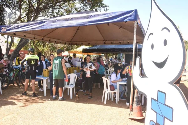 Imagem colorida de tenda com boneco do sus em meio ao Parque da Cidade debaixo de sol forte - Metrópoles