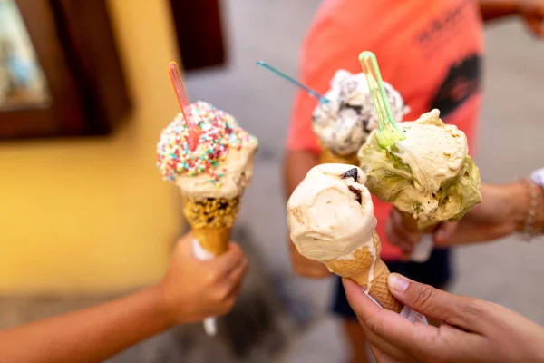 Pessoas segurando casquinhas de sorvete, que é considerado o pior alimento para saúde