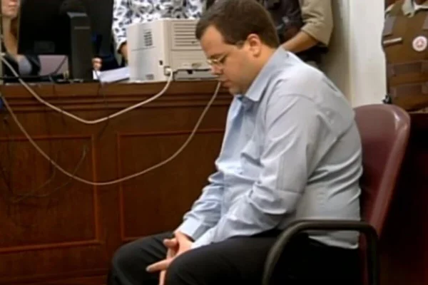 Homem de lado, sentando em cadeira de tribunal - Metrópoles