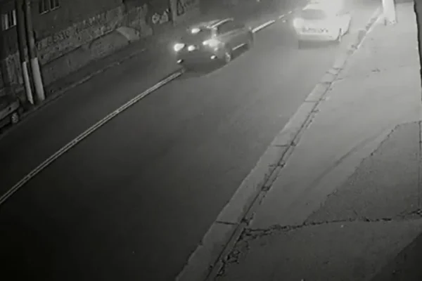 Imagem colorida de carro se aproximando de viatura da PM antes de disparo feito por suspeito. Metrópoles