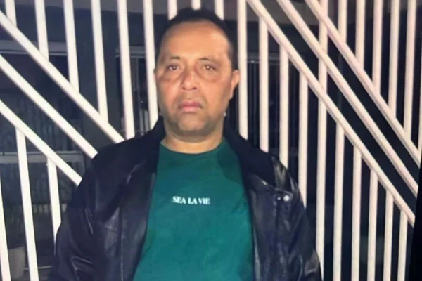 Imagem colorida mostra homem branco com cabelos castanhos escuros. Ele veste camiseta verde e jaqueta preta - Metrópoles