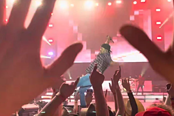 foto colorida de homem caindo em palco de show - metrópoles