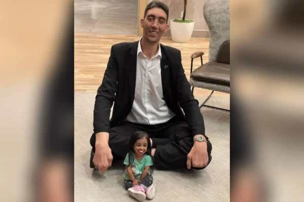 imagem colorida homem mais alto e mulher mais baixa do mundo se encontram em evento