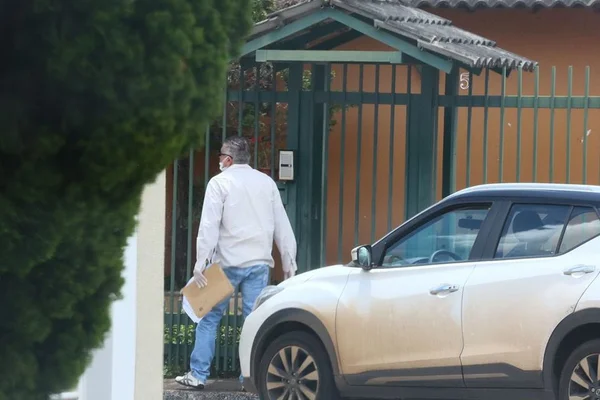 Oficial de Justiça, com máscara, tenta falar com marido de paciente que tem coronavírus
