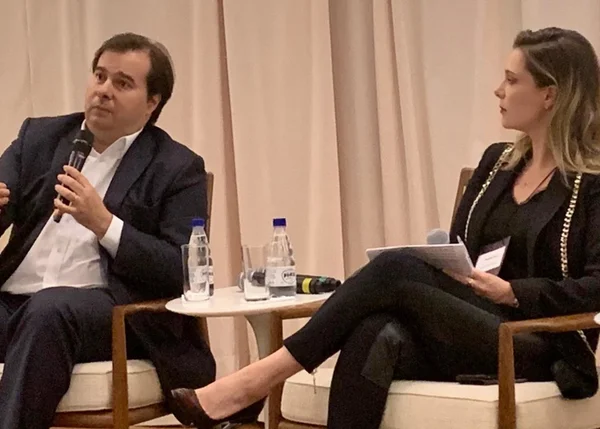 Presidente da Câmara, Rodrigo Maia, sentado ao lado da presidente da ONG Todos Pela Educação, Priscila Cruz, em evento de 2019