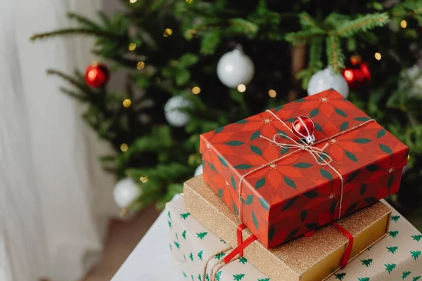 Na foto, presentes de Natal com uma árvore ao fundo - Metrópoles