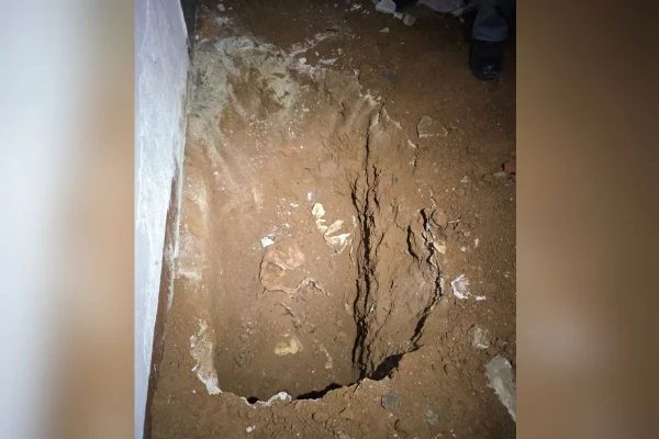 Foto colorida de cova em que mulher foi enterrada dentro de quarto no bairro Itaquera, zona leste de São Paulo.