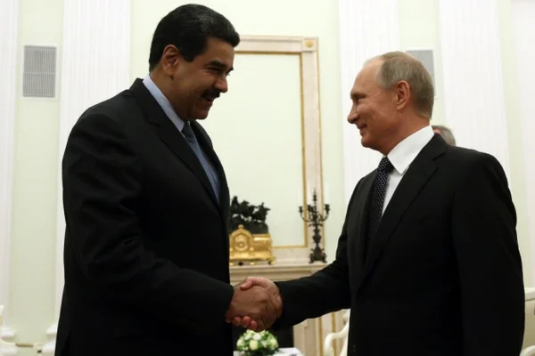 Imagem colorida mostra Putin e Maduro dando aperto de mão - Metrópoles