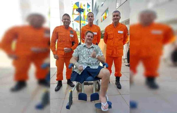 Policial sentado em cadeira de rodas com três colegas do cbmdf
