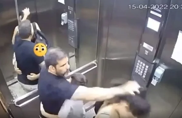 Imagem colorida de homem batendo em mulher dentro de um elevador - Metrópoles