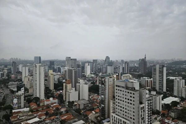 Céu com nuvens cinzas sobre cidade de São Paulo; diversos prédios cobertos por leve neblina - Metrópoles