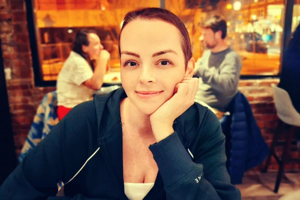Mulher com casaco azul e cabelo raspado - Metrópoles