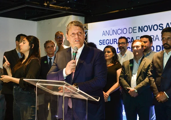 Imagem colorida mostra Tarcísio de Freitas, homem branco e grisalho, de terno azul escuro, camisa branca e gravata, falando em um púlpito transparente, ao microfone, em um palco, com várias pessoas ao fundo - Metrópoles