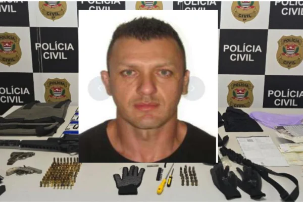 Homem branco, sem barba, cabelo curto. Ao fundo, armas e munições dispostas em mesa - Metrópoles