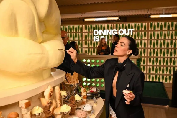 mulher se servindo em bar de manteiga com escultura gigante
