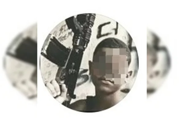 “Dedão” para a PM: adolescente agredido posa com fuzil e fumando