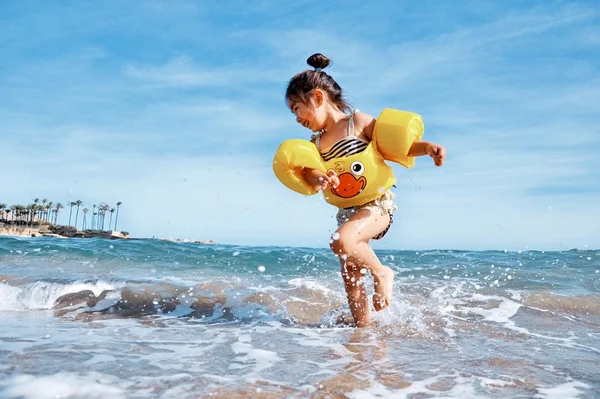 Criança brincando na praia