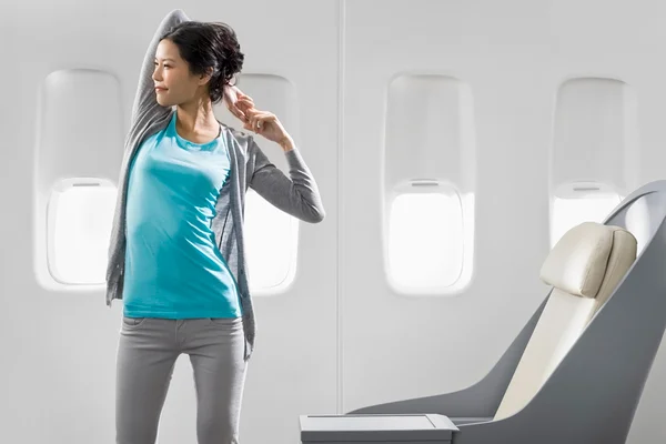 mulher fazendo alongamento em avião