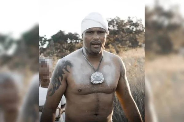 Homem, sem camisa, com colar típico de religião de matriz africana com gorro branco - Metrópoles