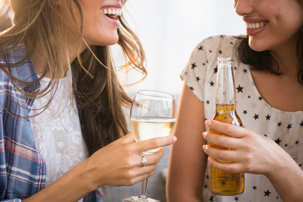 Foto mostra duas mulheres jovens com suas bebidas preferidas - Metrópoles - álcool bebidas saúde