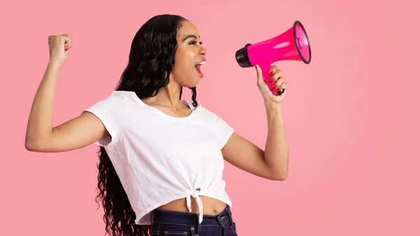 Mulher com megafone em fundo rosa